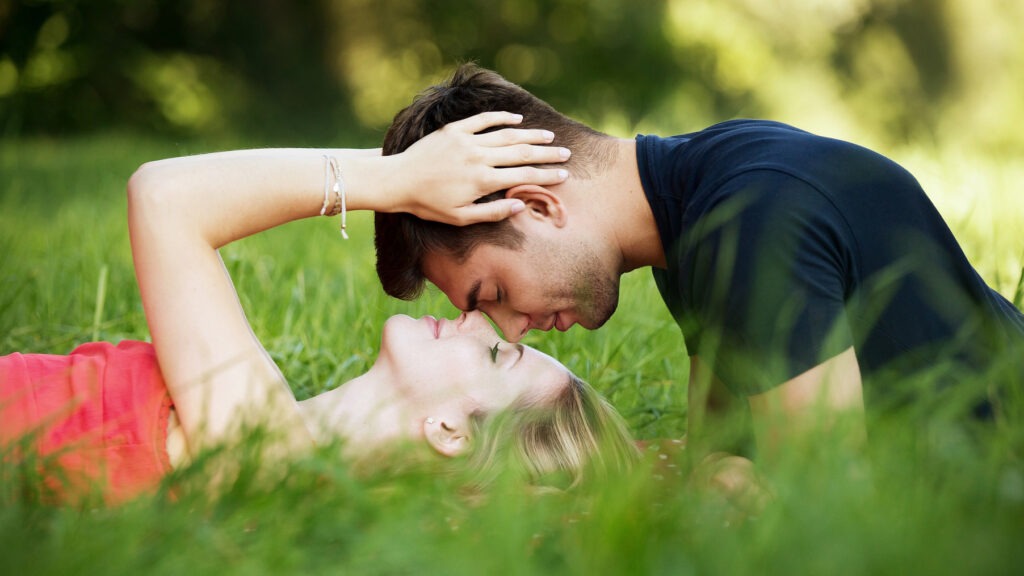 attachment styles and relationships. A couple shows mutual affection while lying on the grass.