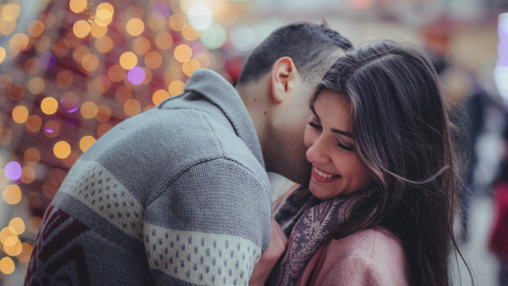 A young couple embraces at a shopping center