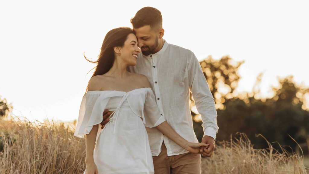 A loving couple shares an intimate moment at sunset. From the article: "7 signs you are healing your attachment style"